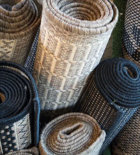 Rolled rugs in various patterns and colours.
