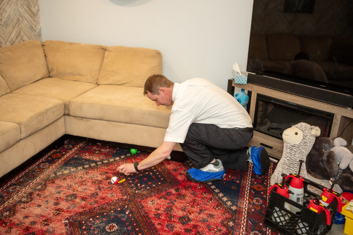 Man removing stain on rug using the best carpet stain removal methods