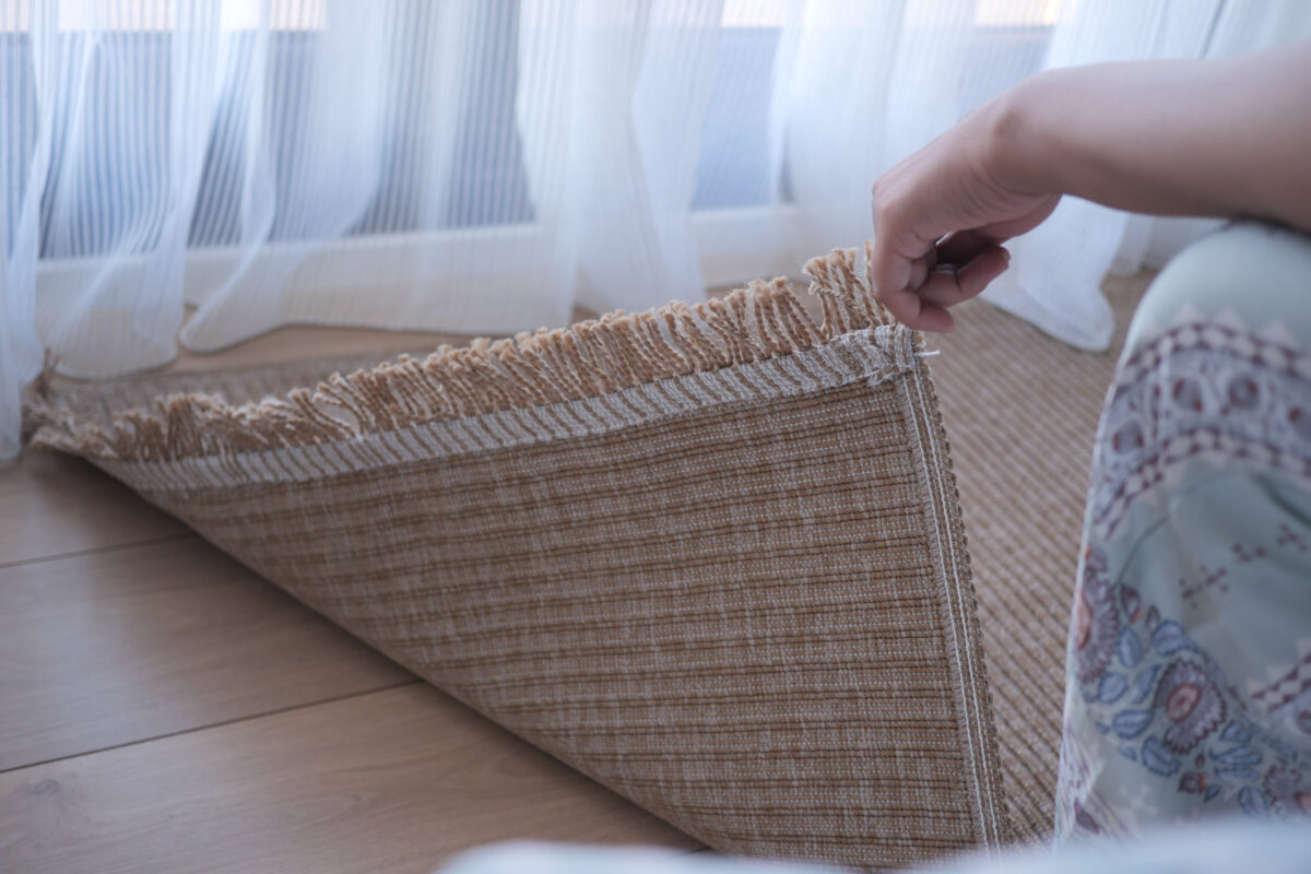 area rug backing ★ Prestige Carpet Cleaning Woman inspecting back of her area rug before choosing area rug cleaning method